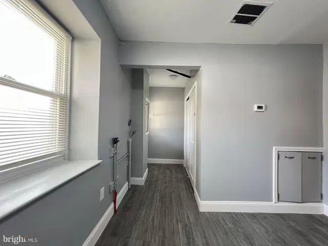 a view of hallway with a large window and wooden floor