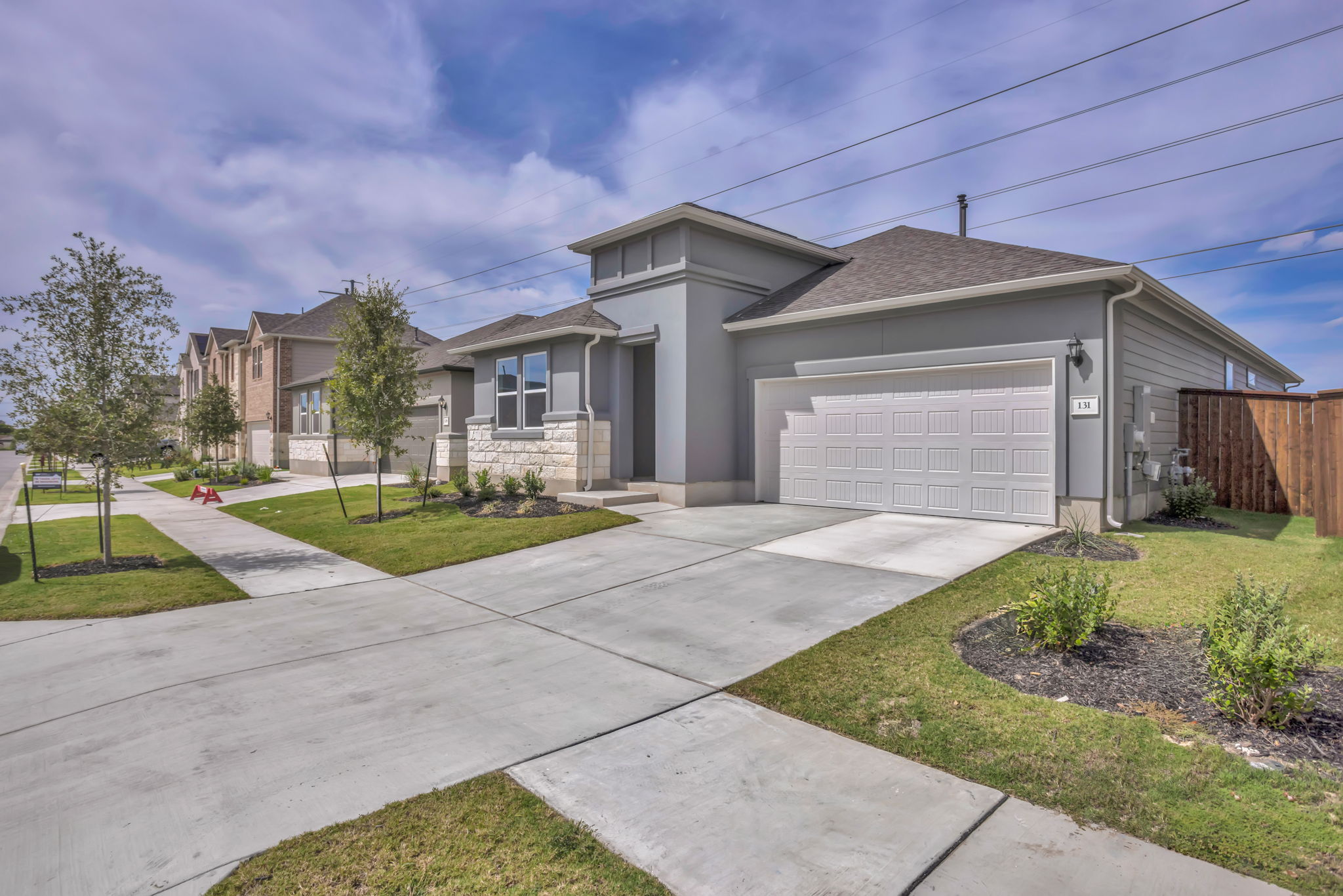 A well-maintained suburban home featuring a clean concrete driveway and verdant lawn.