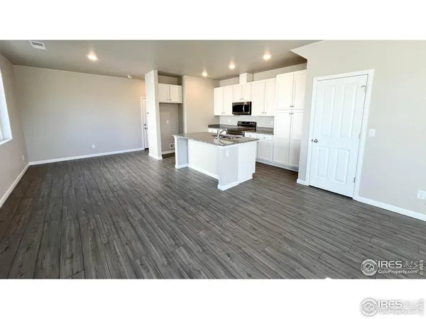 a kitchen with cabinets and wooden floor