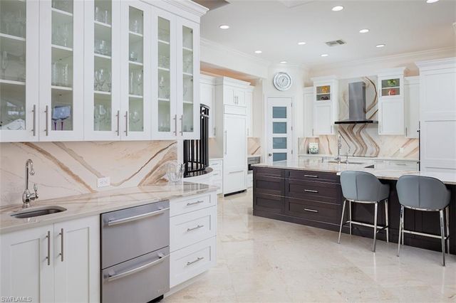 a kitchen with cabinets appliances and a dining table