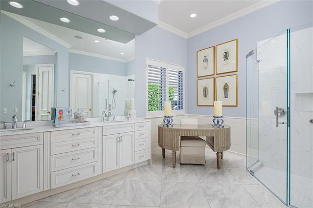a spacious bathroom with a double vanity sink a mirror a bathtub and next to a window