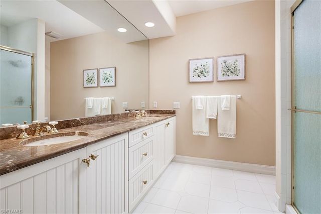 a bathroom with a granite countertop double vanity sink a mirror and