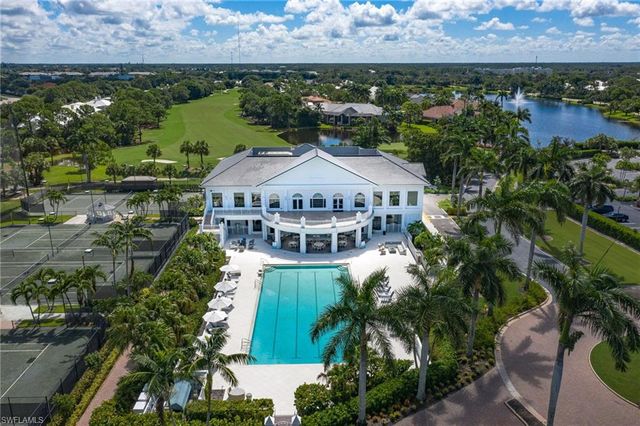 a dining room with wooden floor a chandelier a wooden table and chairs
