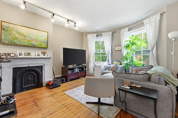 a living room with furniture a flat screen tv and a fireplace