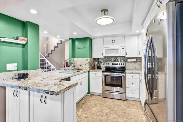 a kitchen with kitchen island a stove a sink and a refrigerator