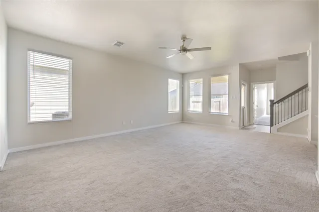 en empty room with ceiling fan and window