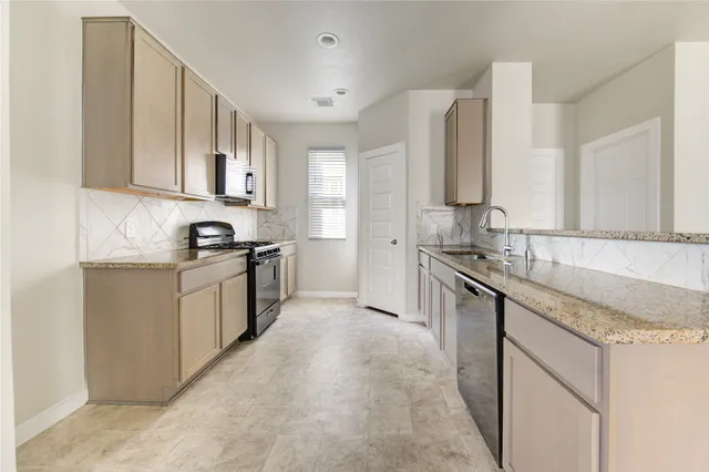 a kitchen with a stove top oven a sink and a window
