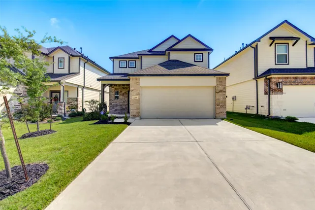 a front view of a house with a yard and trees