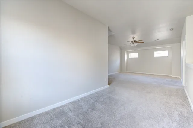 a view of a livingroom with a ceiling fan and window