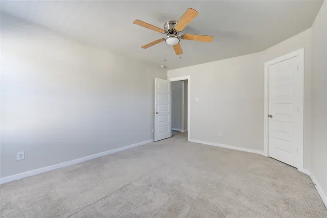 an empty room with chandelier fan