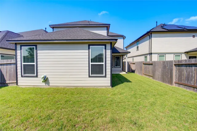 a view of backyard of house with wooden fence