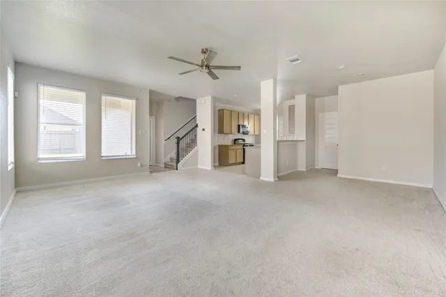 a view of a kitchen with refrigerator and white cabinets