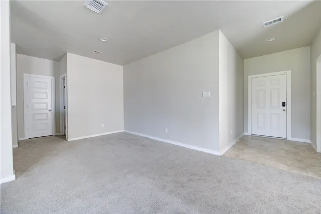 an empty room with a window and a ceiling fan
