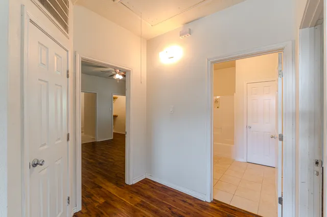 a view of an empty room with window and wooden floor