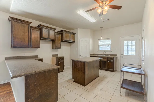 a kitchen with stainless steel appliances granite countertop a sink and a refrigerator