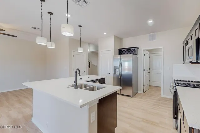 a kitchen with stainless steel appliances a sink a refrigerator and a stove