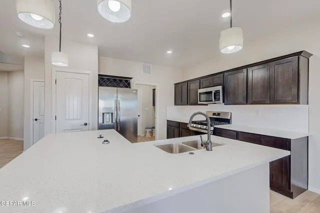 a kitchen with stainless steel appliances a refrigerator sink and microwave