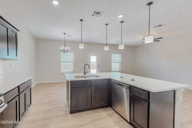 a kitchen with a sink a counter space appliances and cabinets