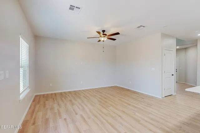 an empty room with fan and windows