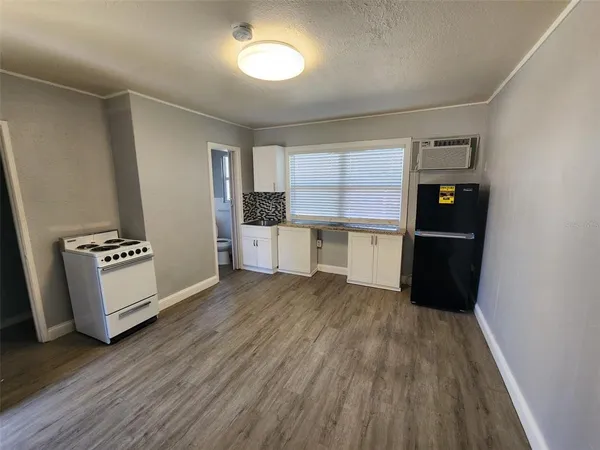 a view of a kitchen with a fridge and wooden floor