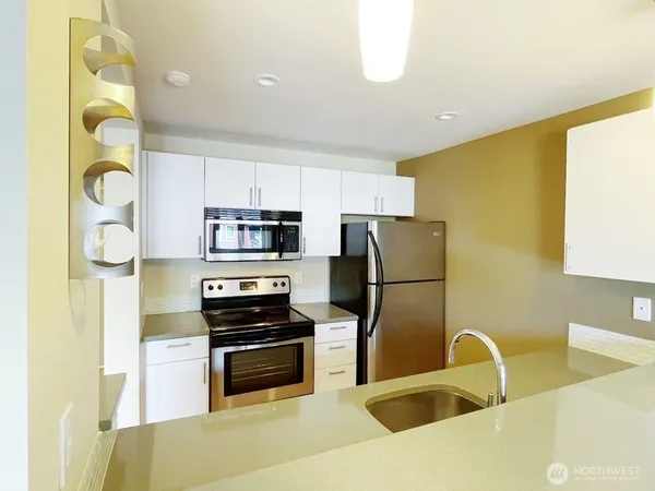 a kitchen with stainless steel appliances a refrigerator sink and stove top oven