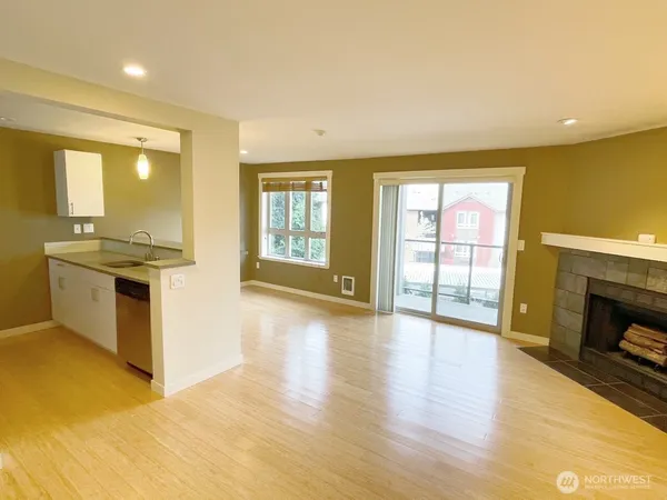 a view of a livingroom with wooden floor and a fireplace