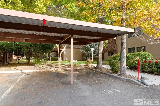 a view of a patio with table and chairs under an umbrella with a small yard