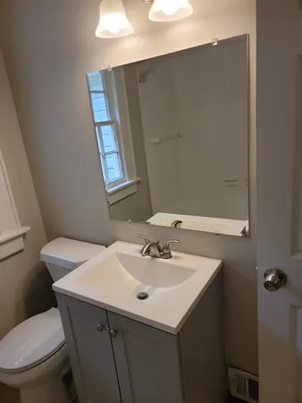 a bathroom with a sink a toilet and mirror
