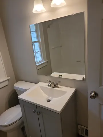 a bathroom with a sink a toilet and mirror