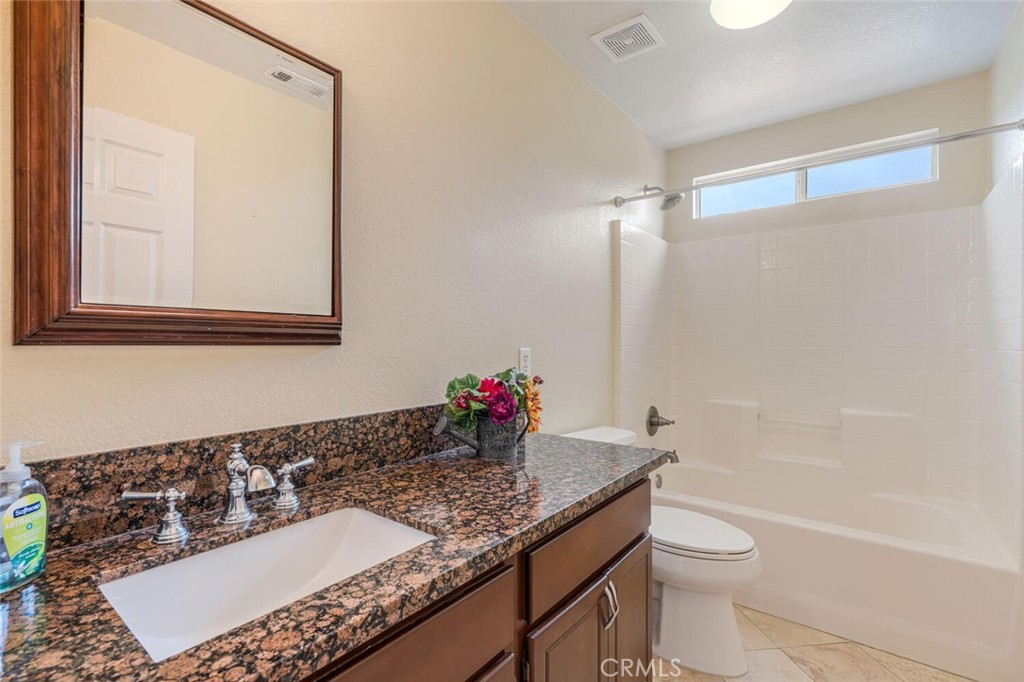 17262 Hawkwood Drive Riverside, CA 92503 - Photo 22 of 33 a bathroom with a granite countertop sink a toilet and shower