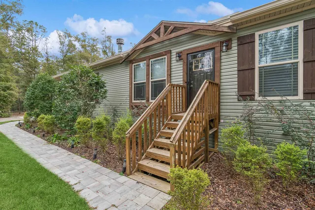 a kitchen with stainless steel appliances granite countertop a refrigerator a sink dishwasher a stove and white countertops with wooden floor