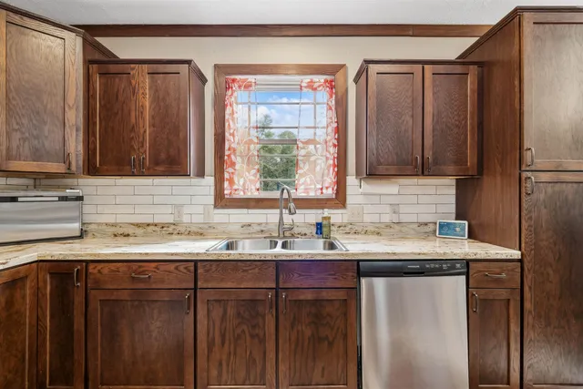 a kitchen with stainless steel appliances granite countertop a sink refrigerator and microwave