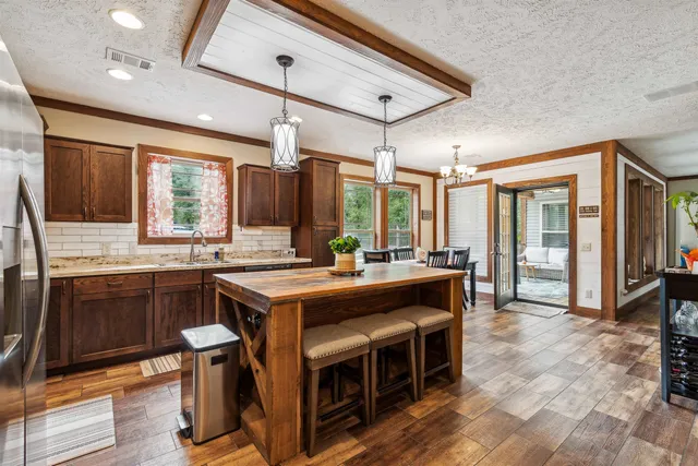 a kitchen with stainless steel appliances granite countertop a sink a stove and wooden cabinets