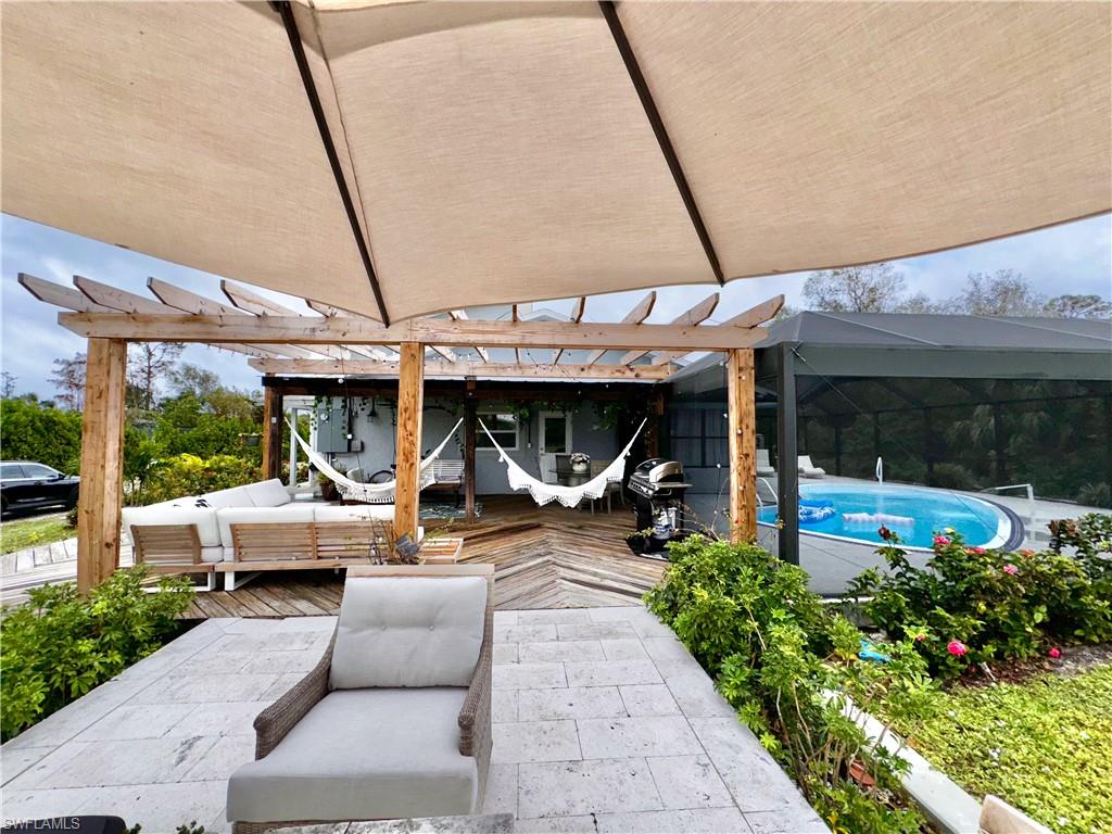 3220 63rd Street Southwest Naples, FL 34105 - Photo 4 of 36 View of patio featuring an outdoor living space, a deck, a pergola, an outdoor pool, and a grill