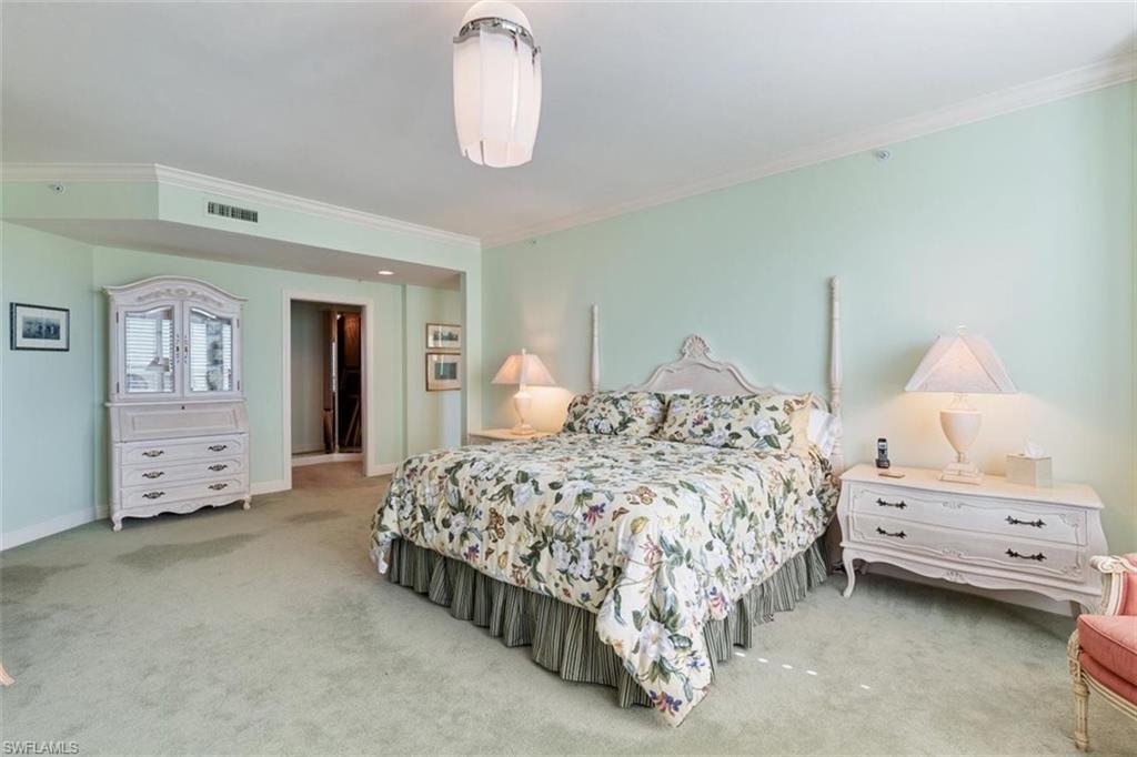 285 Grande Way, Unit 1501 Naples, FL 34110 - Photo 16 of 35 a bedroom with a bed and a chandelier