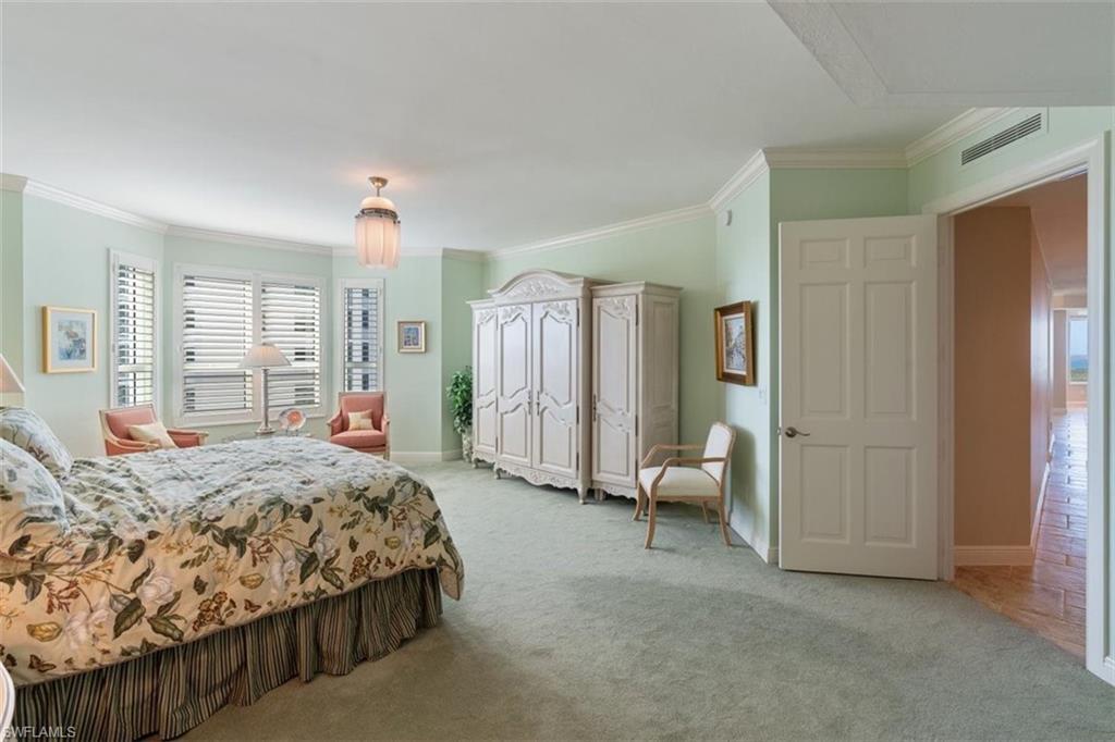 285 Grande Way, Unit 1501 Naples, FL 34110 - Photo 18 of 35 a spacious bedroom with a bed and large window