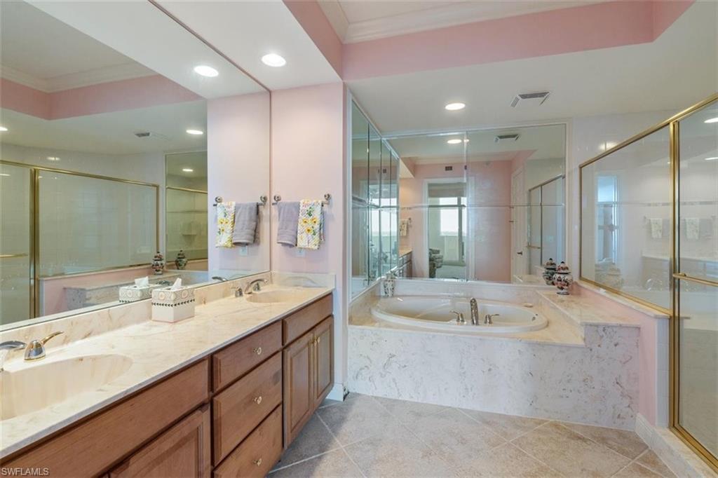 285 Grande Way, Unit 1501 Naples, FL 34110 - Photo 22 of 35 a spacious bathroom with a large mirror vanity and shower