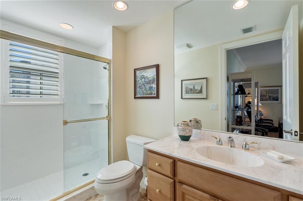 285 Grande Way, Unit 1501 Naples, FL 34110 - Photo 25 of 35 a bathroom with a granite countertop sink toilet a large mirror and shower