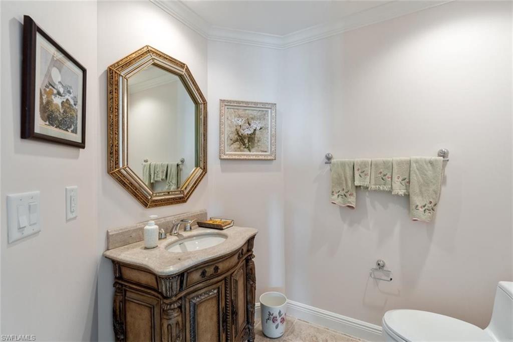 285 Grande Way, Unit 1501 Naples, FL 34110 - Photo 28 of 35 a bathroom with a toilet a sink and mirror