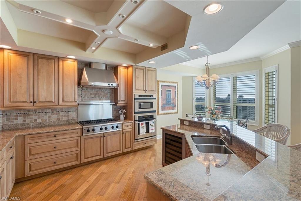 285 Grande Way, Unit 1501 Naples, FL 34110 - Photo 5 of 35 a kitchen with stainless steel appliances granite countertop a stove a sink and a refrigerator