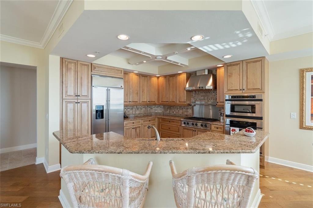 285 Grande Way, Unit 1501 Naples, FL 34110 - Photo 6 of 35 a kitchen with kitchen island granite countertop a stove and a sink