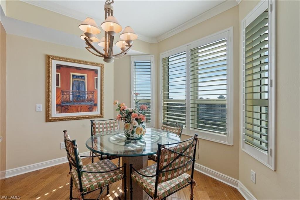 285 Grande Way, Unit 1501 Naples, FL 34110 - Photo 8 of 35 a dining room with chandelier and wooden floor