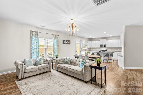 a living room with furniture and a chandelier