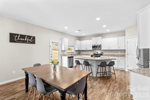 a open dining room with kitchen island a table and chairs