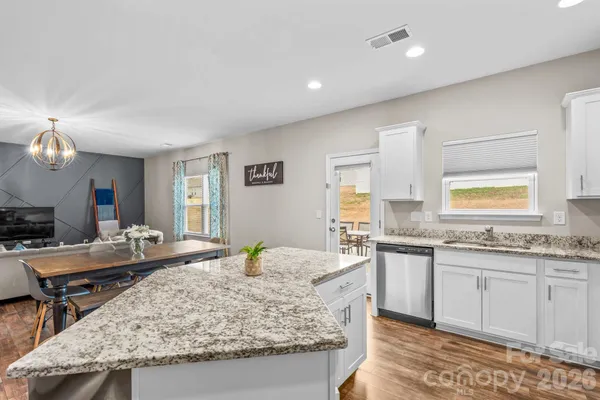 a large kitchen with granite countertop a sink and a stove