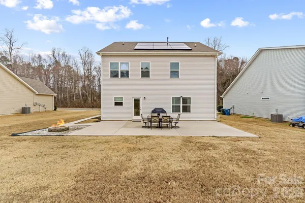 a view of a house with backyard and a tree