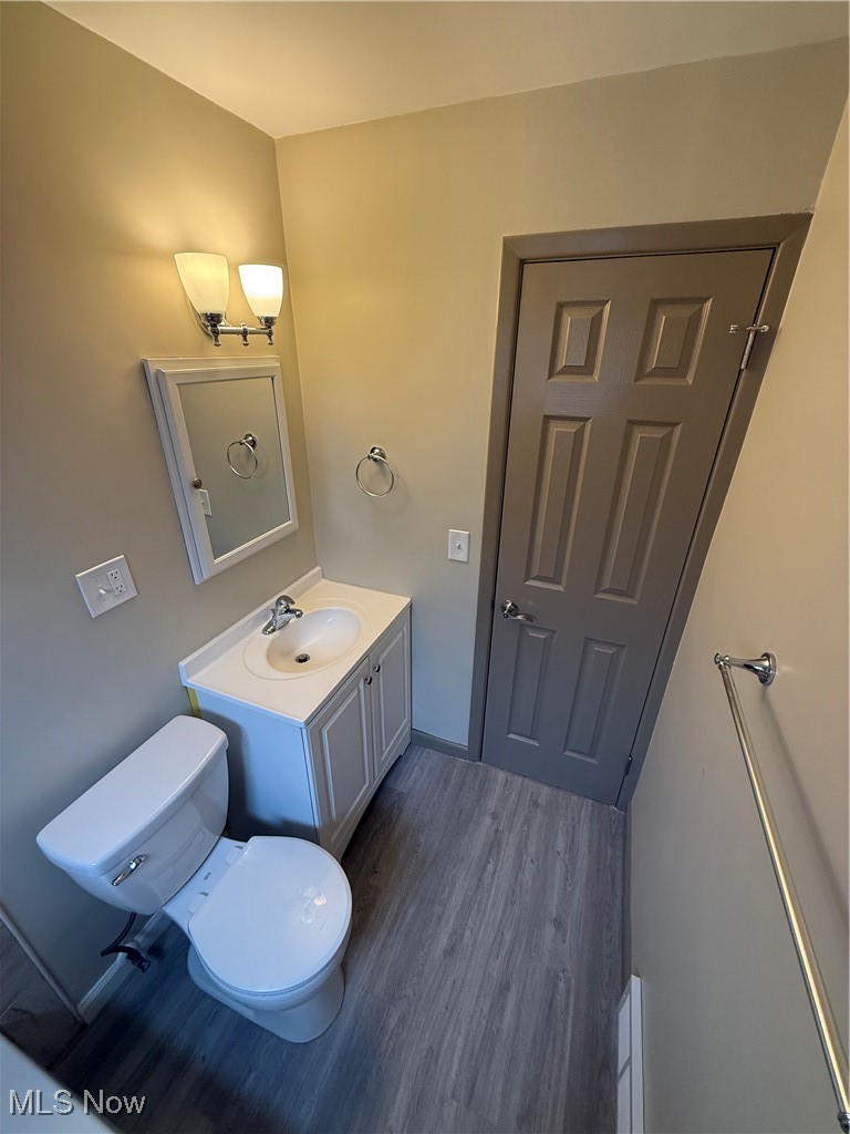 9417 Alexander Road Garfield Heights, OH 44125 - Photo 25 of 38 Half bathroom featuring toilet, vanity, and wood finished floors