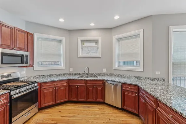 a kitchen with stainless steel appliances granite countertop a stove sink and microwave