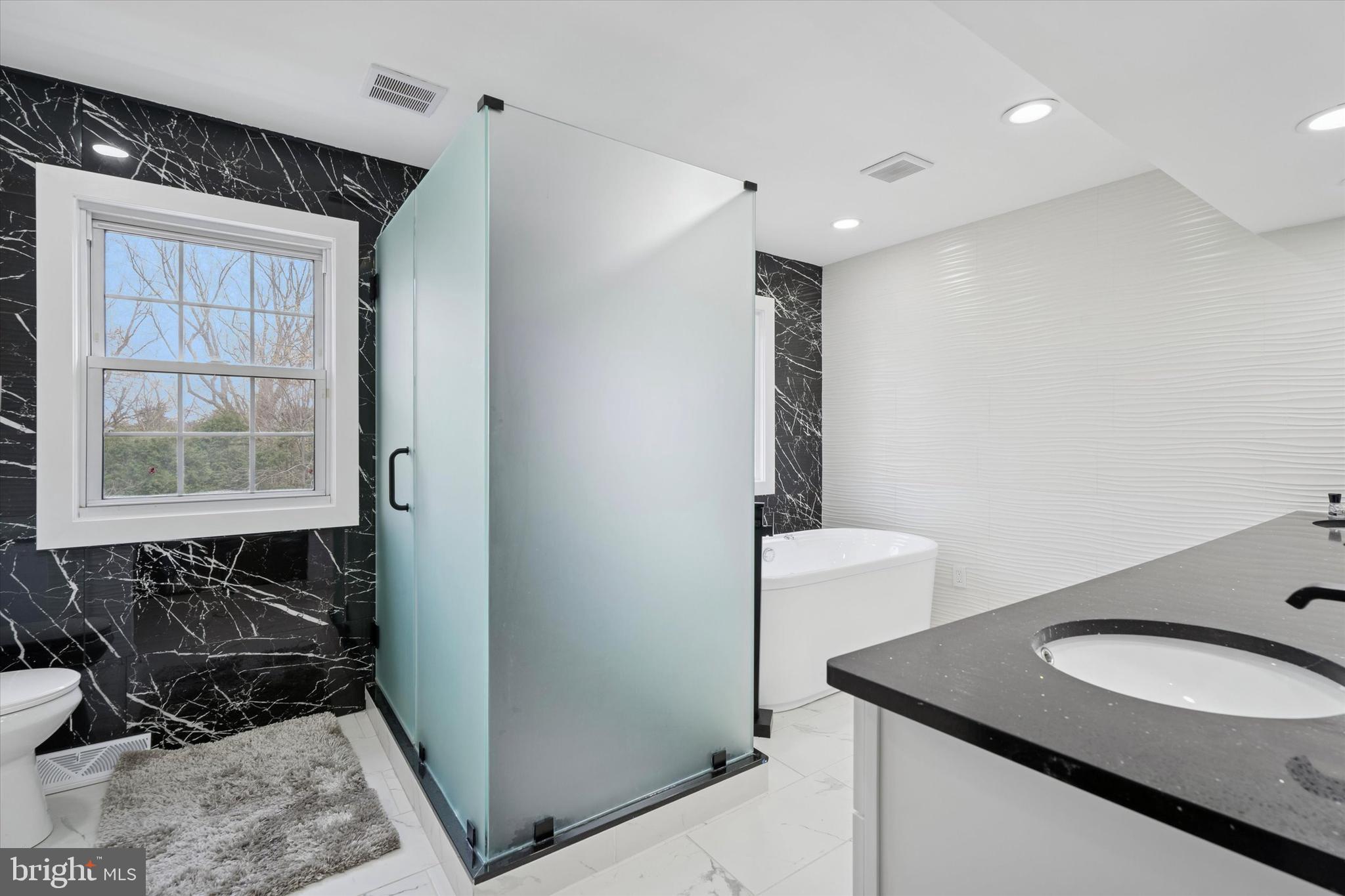 125 Red Lion Road Huntingdon Valley, PA 19006 - Photo 23 of 32 a bathroom with a granite countertop sink a toilet a mirror and shower