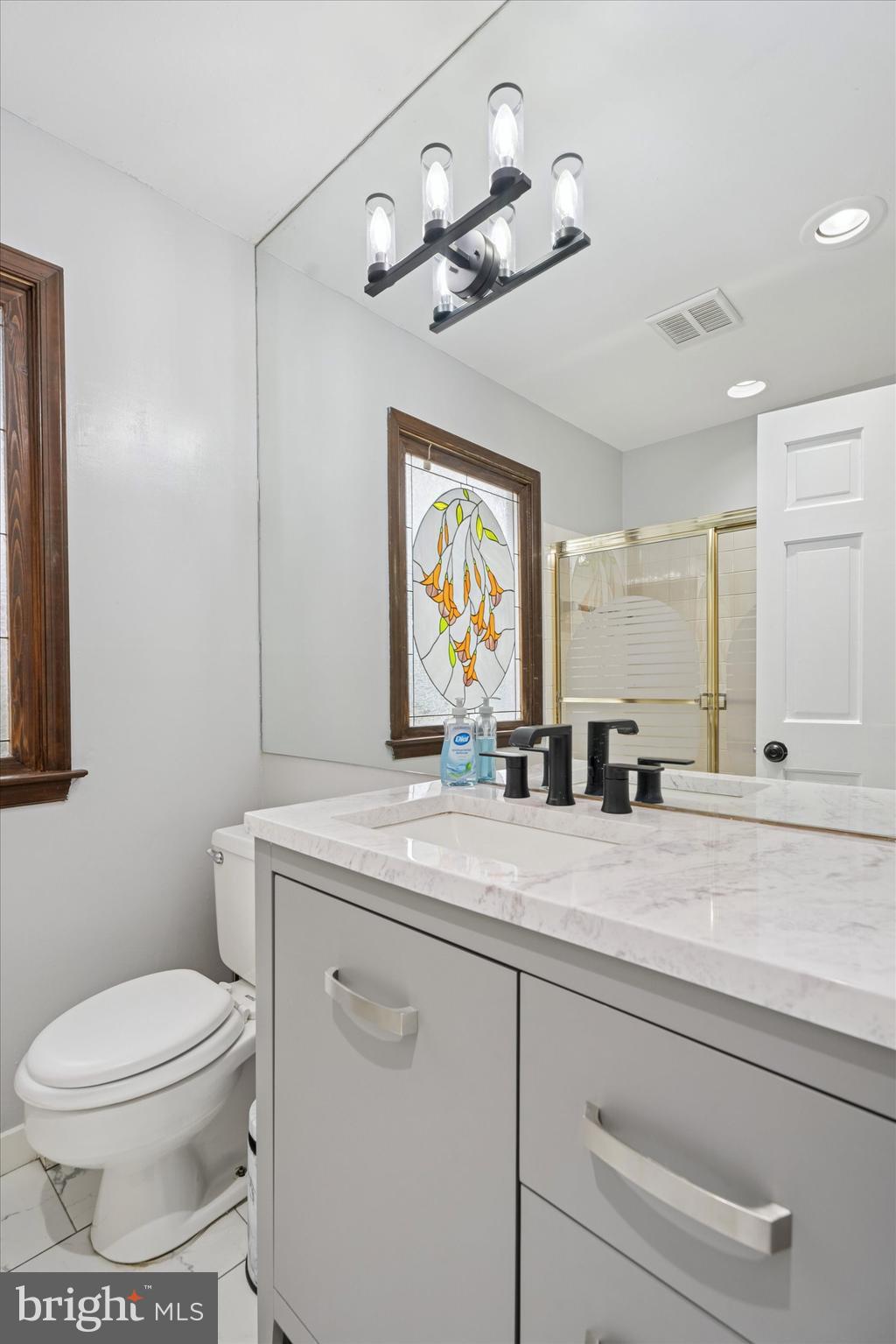 125 Red Lion Road Huntingdon Valley, PA 19006 - Photo 24 of 32 a bathroom with a granite countertop sink a toilet and a mirror